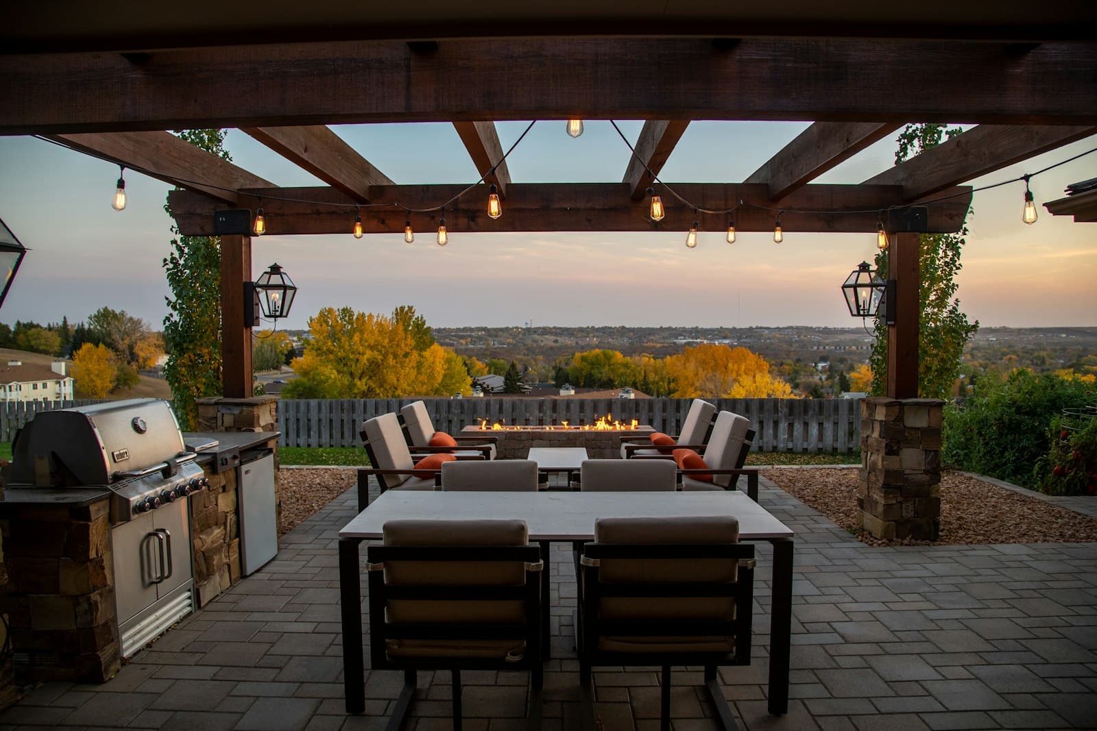Wooden dining table and chairs beneath a pergola